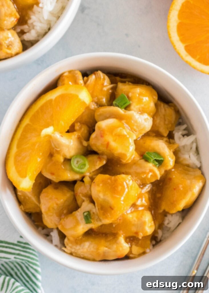 Zesty Orange Chicken 5 A top-down view of a bowl filled with perfectly cooked orange chicken served over a bed of fluffy white rice.