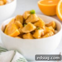 Zesty Orange Chicken 8 Close up of delicious orange chicken in a white bowl, ready to eat.