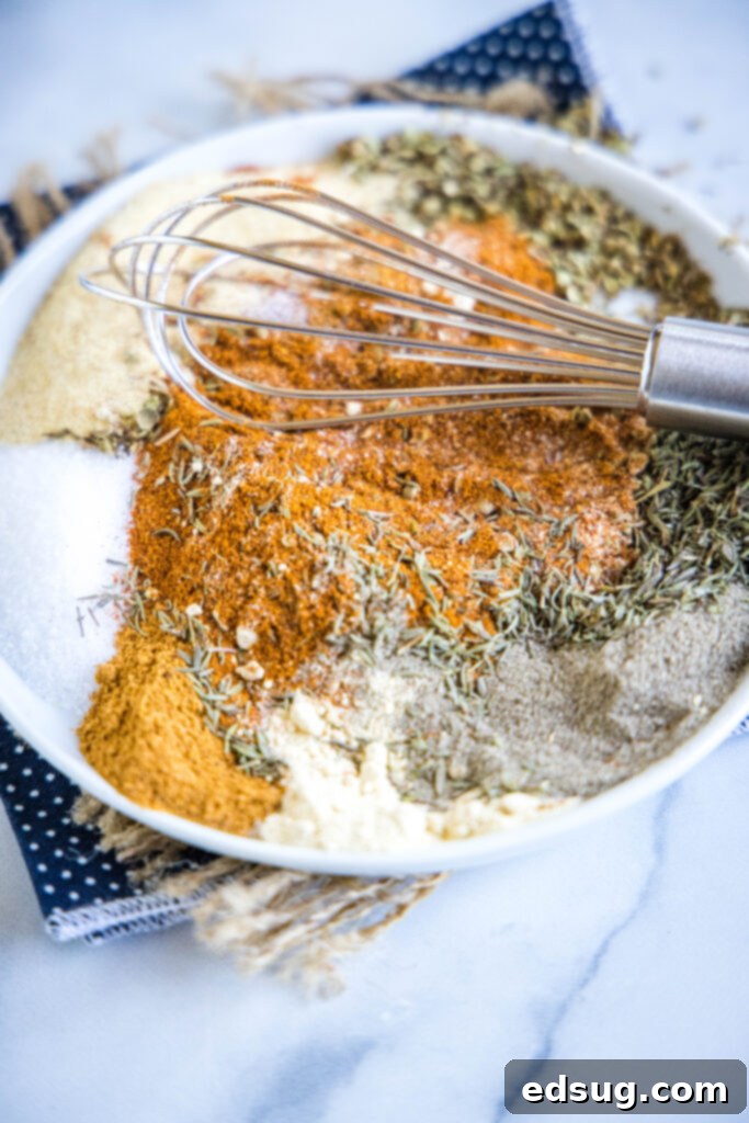 Bring the Bayou Home: Homemade Cajun Blend 4 Various spices being thoroughly mixed with a whisk in a small white bowl, illustrating the blending process for Cajun seasoning.