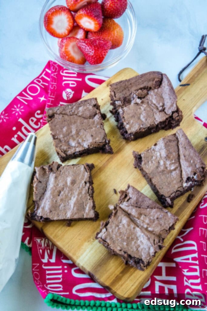 Tray of freshly baked brownies, cut and ready for festive Santa hat decoration.