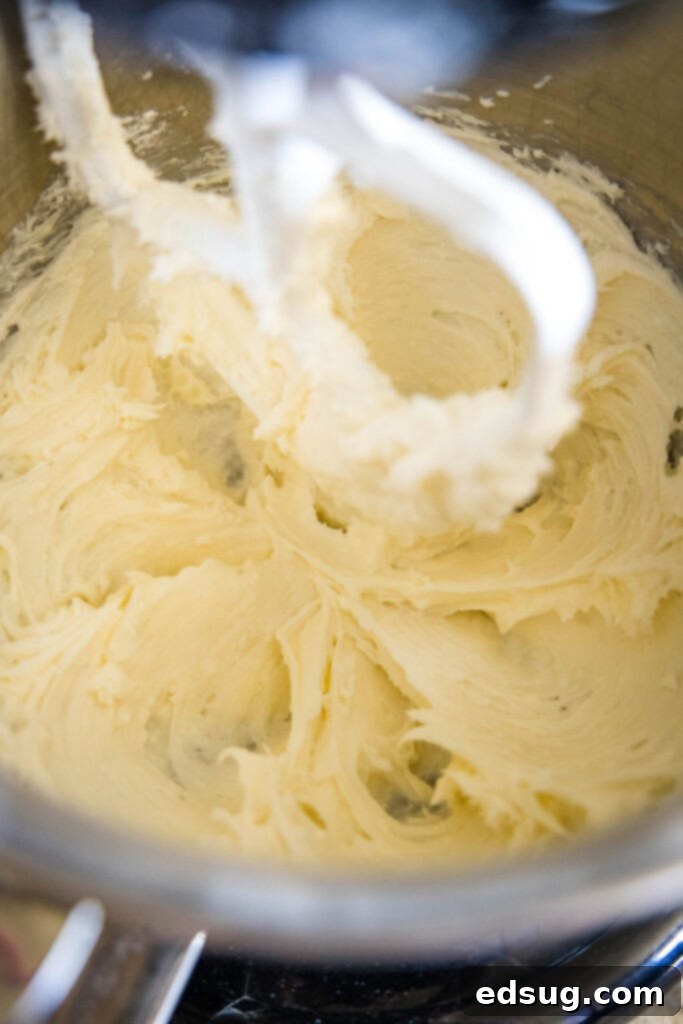 Close up of vanilla frosting being whipped in a stand mixer