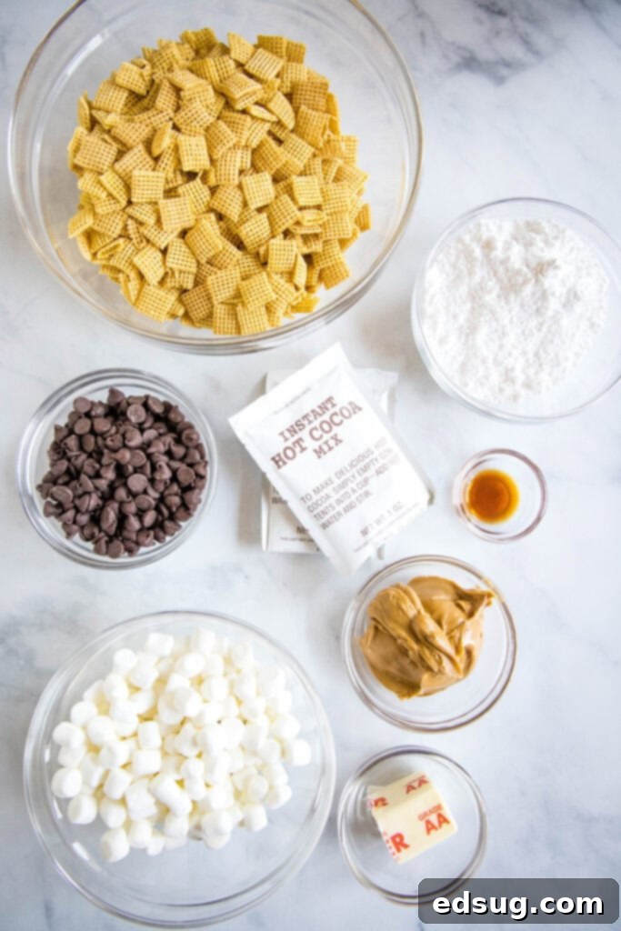 Cozy Cocoa Muddy Buddies 3 Hot chocolate muddy buddies ingredients laid out on a wooden surface, including Chex cereal, chocolate chips, peanut butter, and hot chocolate mix packets