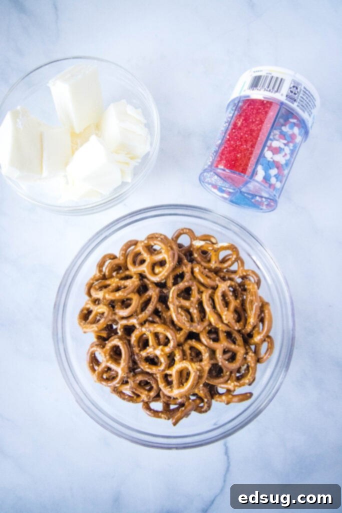 Stars and Stripes Twists 3 Ingredients laid out for making patriotic pretzels: pretzels, white chocolate, and red, white, and blue sprinkles.