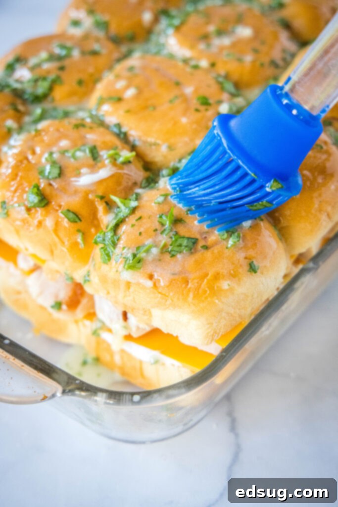 Savory Turkey Sliders 4 brushing butter and parsley over the top of slider buns