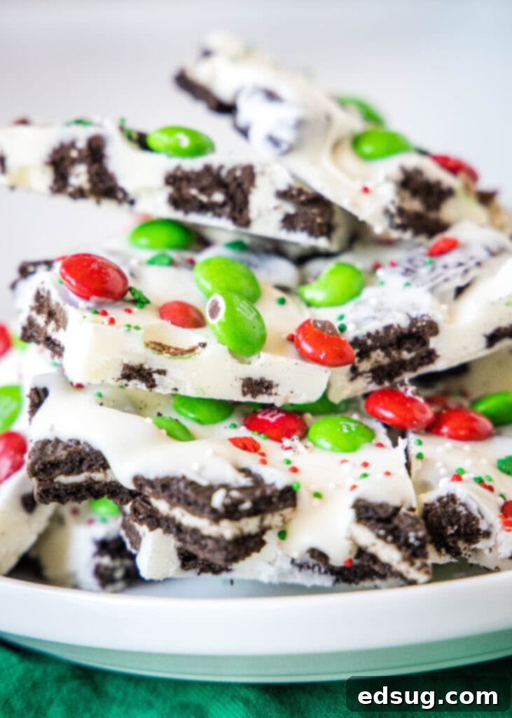 Holiday Candy Bark 2 A beautifully arranged plate of white chocolate Christmas bark, topped with crushed Oreos, red and green M&M's, and festive sprinkles.