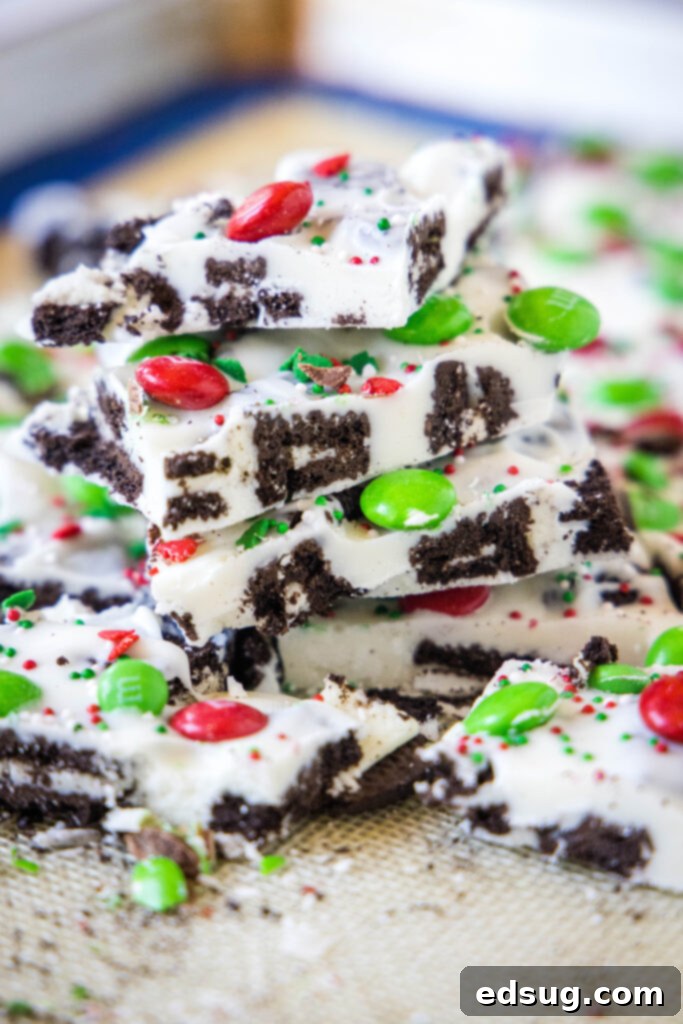 Holiday Candy Bark 7 Freshly cut pieces of white chocolate Christmas bark, showcasing the rough edges and colorful toppings, on a baking tray.