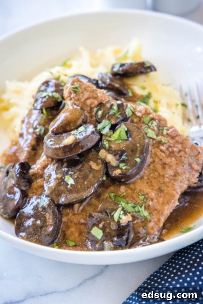 Tender Slow Cooker Cube Steak 2 crockpot cube steak on a plate with mushroom gravy