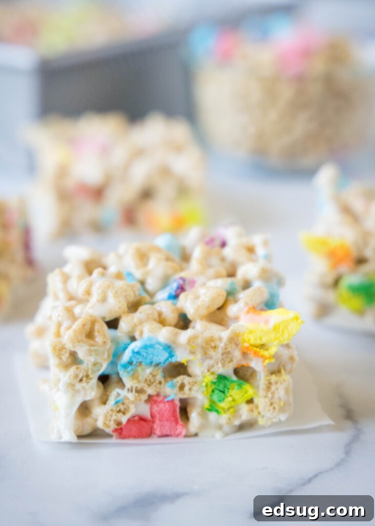 Lucky Charms Rainbow Krispie Delights 6 Lucky Charms Rice Krispie Treats sliced into squares on a wooden table