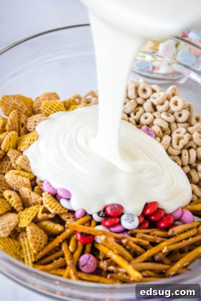 pouring melted white chocolate over cereal mixture