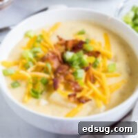 Creamy Instant Pot Potato Soup 2 Close up of a bowl of potato soup topped with cheese, green onions, and bacon.