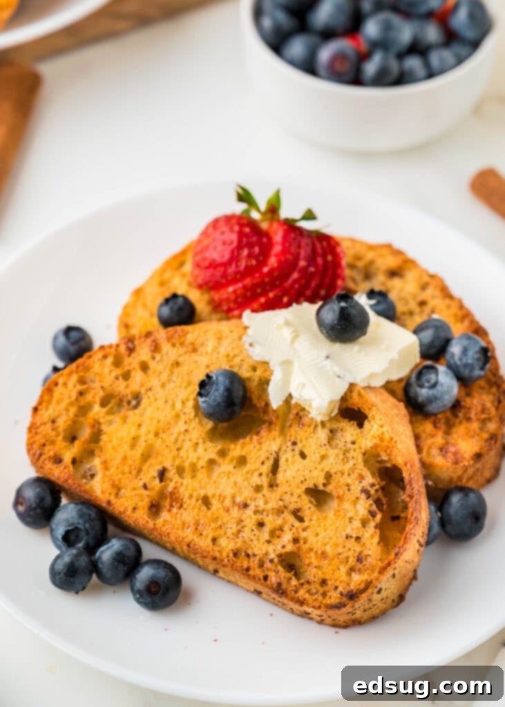Golden Air Fryer French Toast 5 A simple plate with two slices of Air Fryer French Toast, garnished with a sprinkle of berries, ready to be enjoyed.