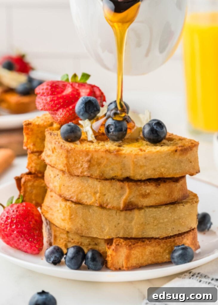Golden Air Fryer French Toast 6 A generous pour of golden maple syrup cascades over a stack of perfectly cooked Air Fryer French Toast, ready to be served.