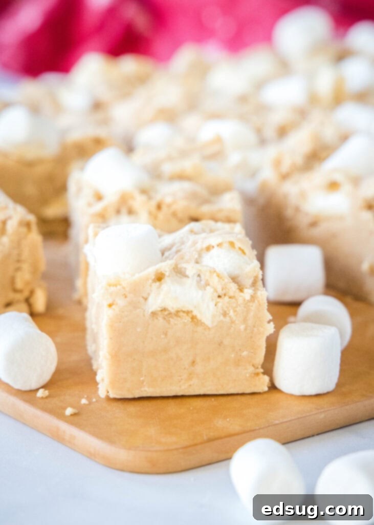Peanut Butter Marshmallow Fudge 2 Decadent squares of peanut butter marshmallow fudge on a cutting board, ready to be devoured.
