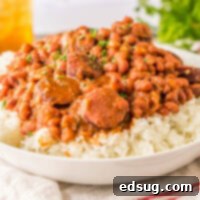 Side view of a plate of red beans and sausage on rice.