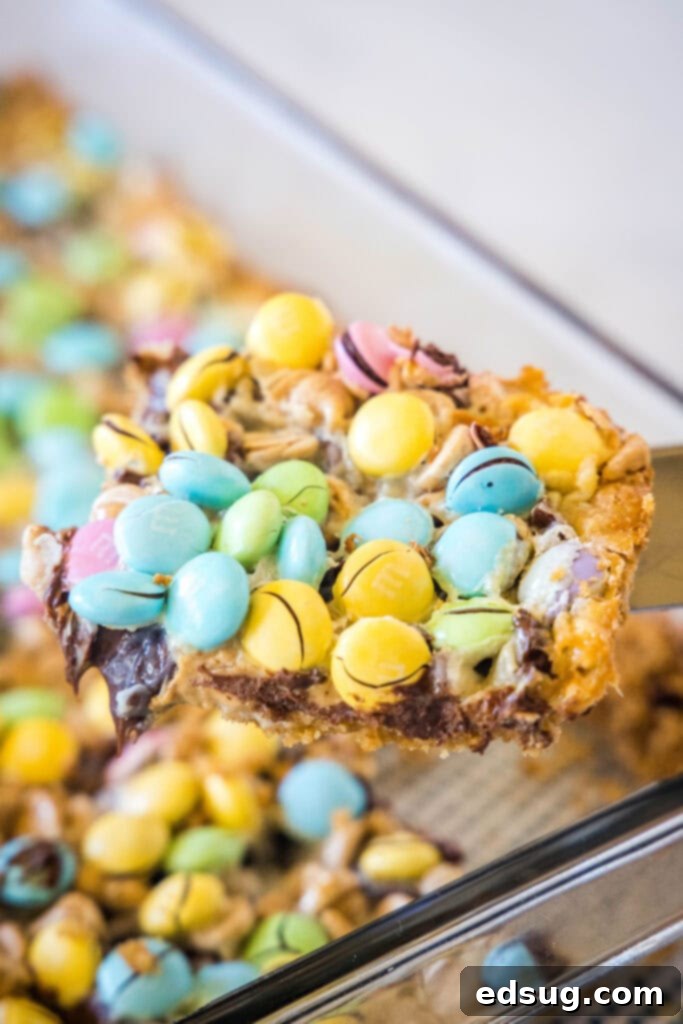 A spatula scooping a perfectly sliced Easter Magic Bar out of the baking pan, showing the distinct layers.