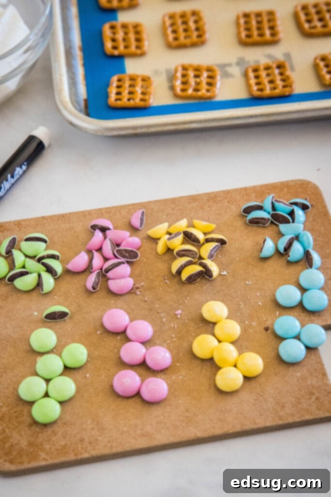 Several M&M's, some whole and some cut in half, on a wooden cutting board