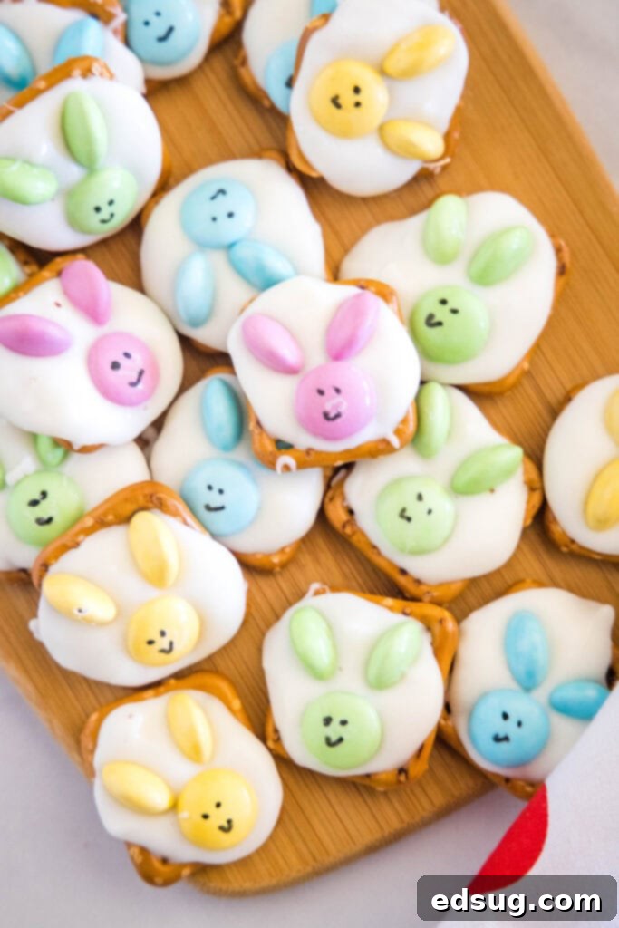 An overhead shot of a wooden cutting board filled with finished bunny pretzels, showing their cute faces and ears