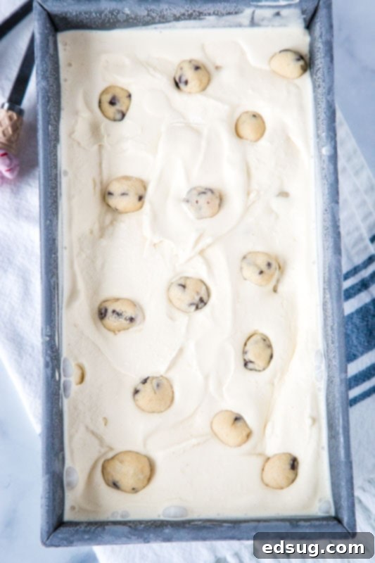 A loaf pan filled with freshly churned homemade cookie dough ice cream, ready to freeze and enjoy.