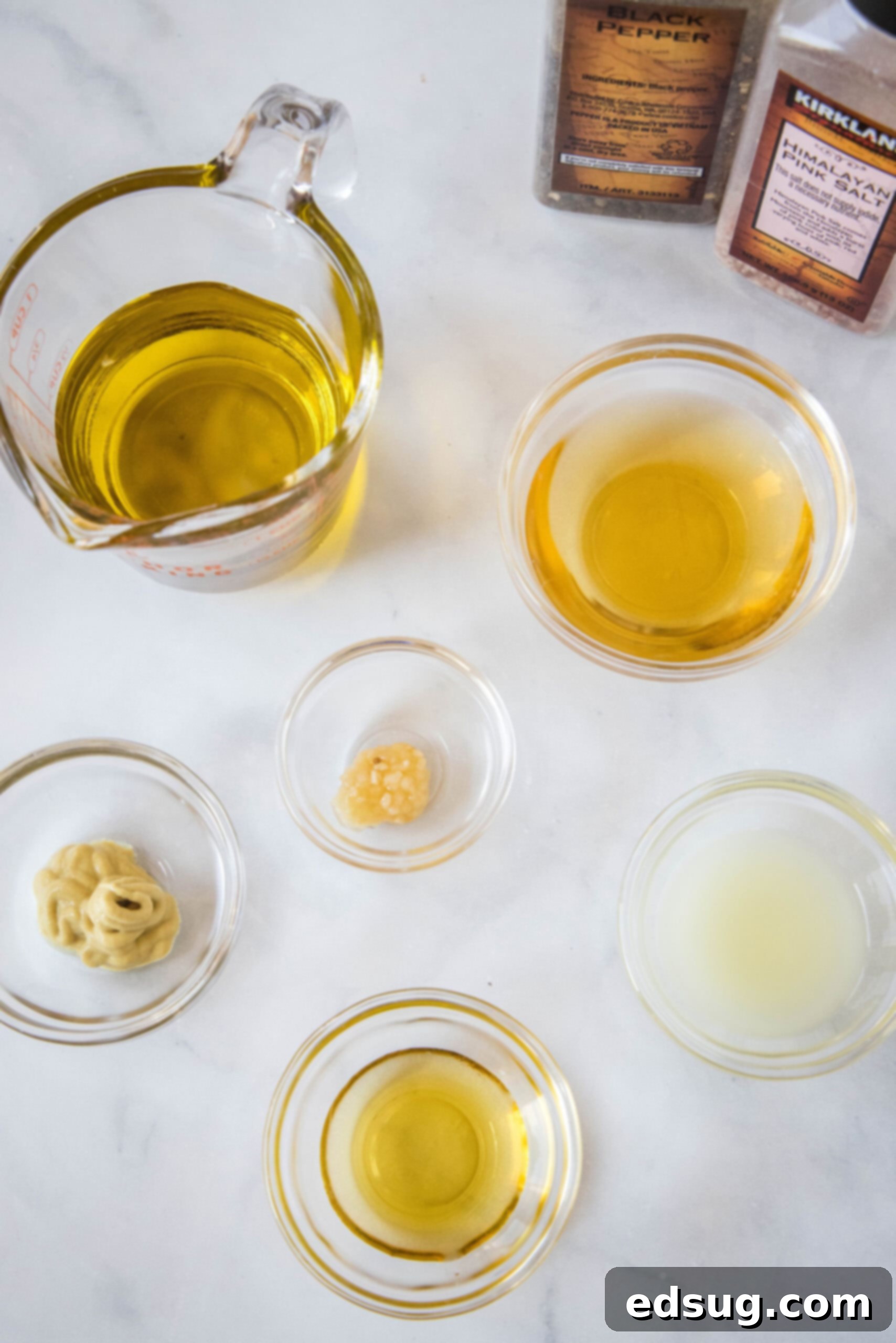 Individual ingredients for easy apple cider vinaigrette laid out on a clean surface.
