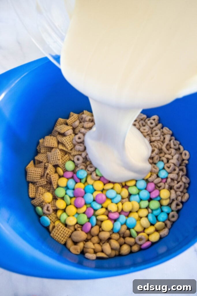 Velvet Trap 4 pouring white chocolate over cereal mixture in a large bowl to make bunny bait
