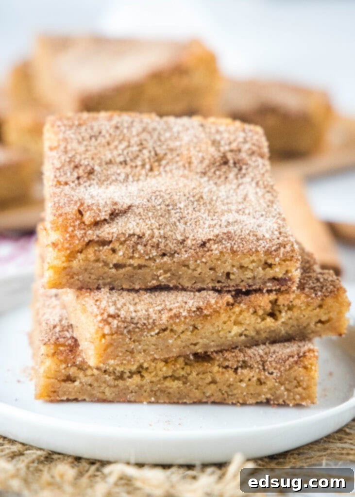 stacked churro bars on a white plate ready to be served