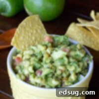 close up bowl of avocado corn salsa with tortilla chips