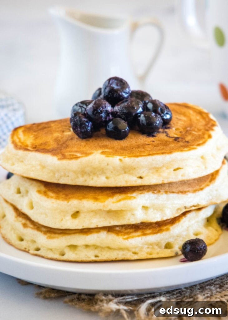 Stack of Greek yogurt pancakes topped with fresh blueberries and syrup