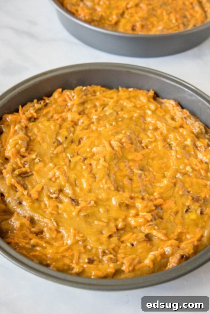 The best homemade carrot cake! Made from moist cake layers loaded with crunchy pecans, filled and frosted with sweet cream cheese frosting. Round pans filled with carrot cake batter.