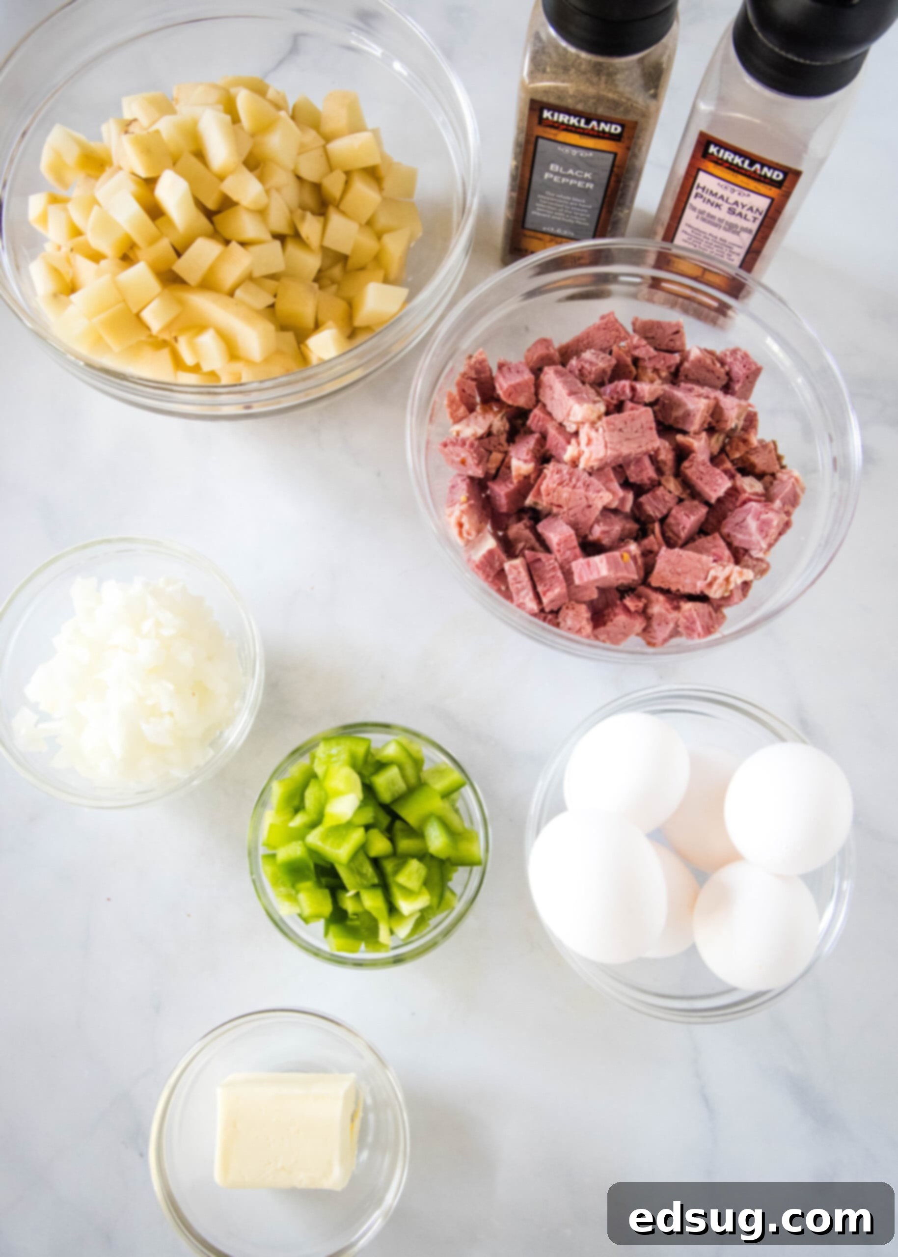 Make homemade corned beef hash with leftover corned beef, tender potatoes, onions, and bell peppers. An easy breakfast, ready in 30 minutes! Ingredients for corned beef and hash laid out on a cutting board, including diced potatoes, chopped corned beef, onion, and bell pepper.