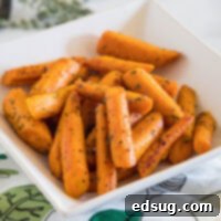 Honey-Glazed Roasted Carrots 2 Seasoned roasted carrots in a square white bowl, ready to be served.