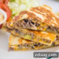 The Cheesy Burger Fold 2 Three slices of cheeseburger quesadilla stacked on a plate.