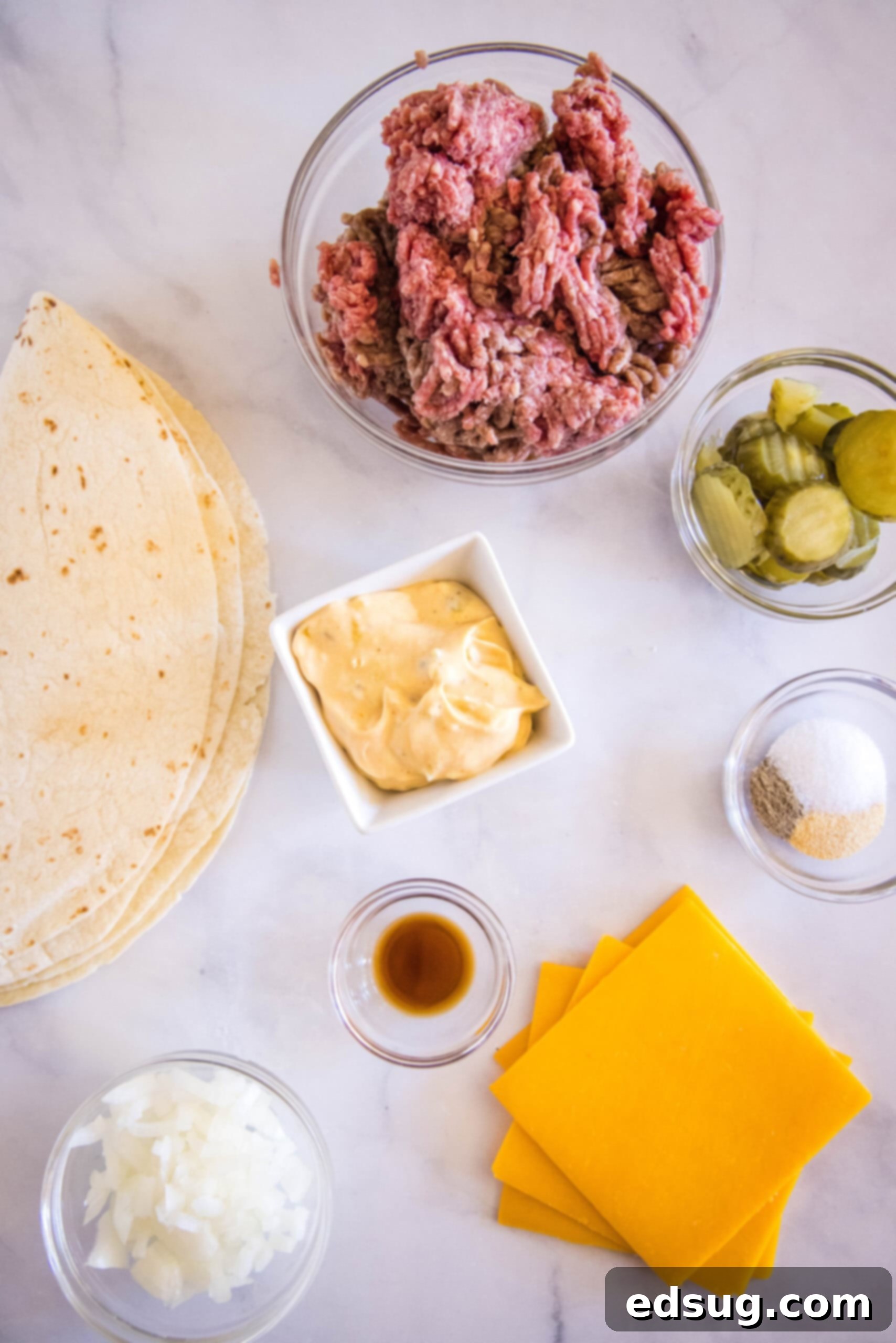 Tuck into a crispy cheeseburger quesadilla loaded with juicy burger meat, onions, pickles, and melty cheese folded inside a warm tortilla. Ingredients for cheeseburger quesadillas.