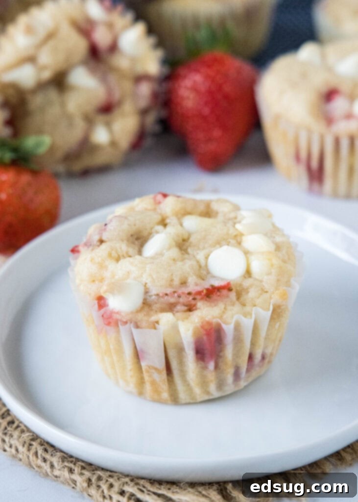 Heavenly Strawberry White Chocolate Chip Muffins 6 a white plate with a strawberry muffin
