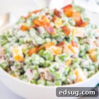 Pea salad in a white bowl.