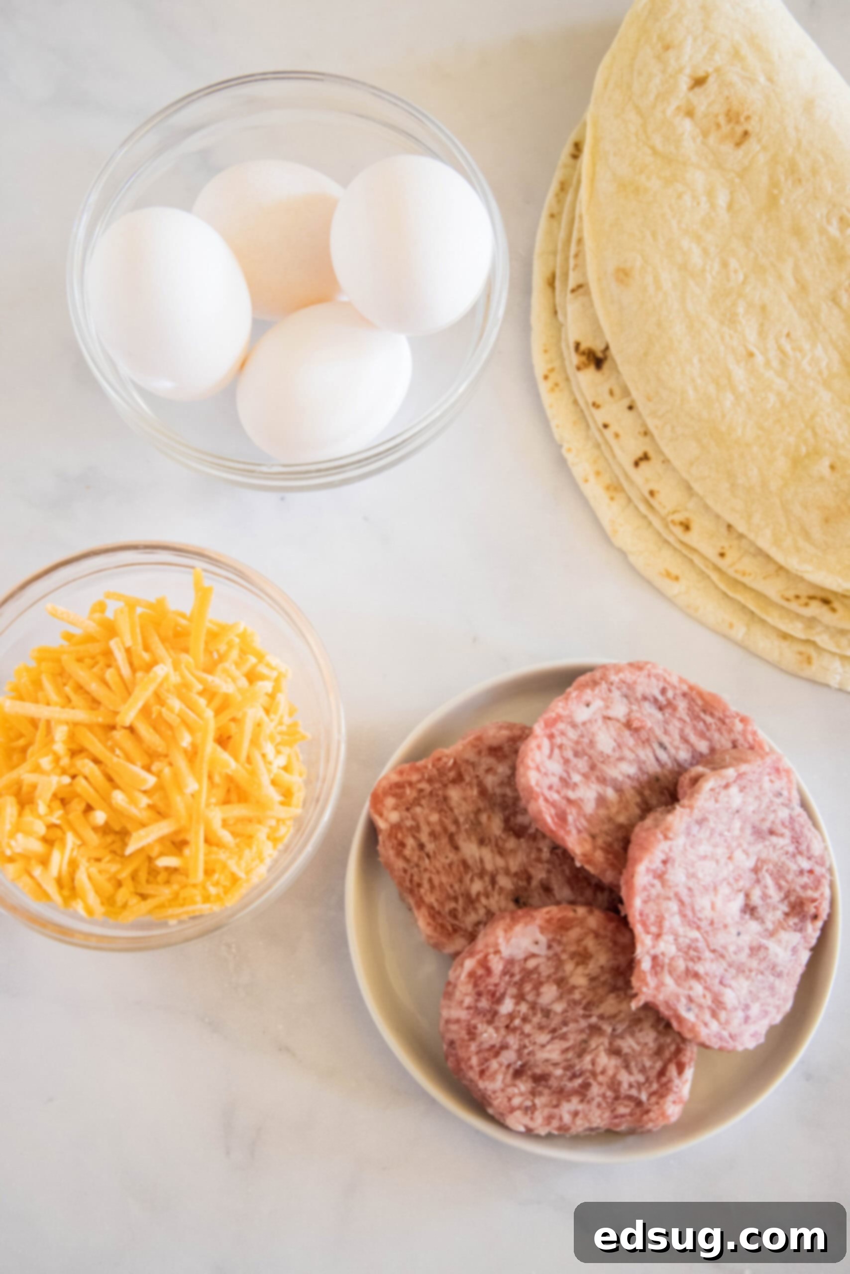 Rise and shine with this easy breakfast quesadilla recipe! Made with eggs, savory sausage, and melty cheese folded between warm tortillas. Fresh ingredients laid out for making breakfast quesadillas.