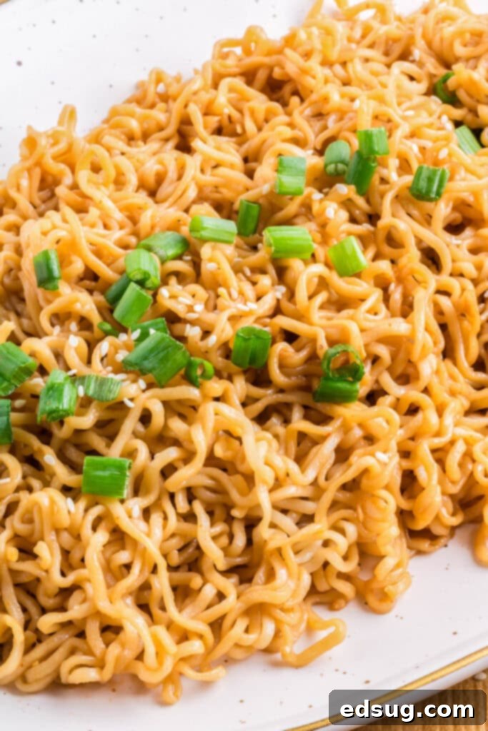 Savory Sesame Noodles 2 sesame noodles on a plate, garnished with green onions and sesame seeds