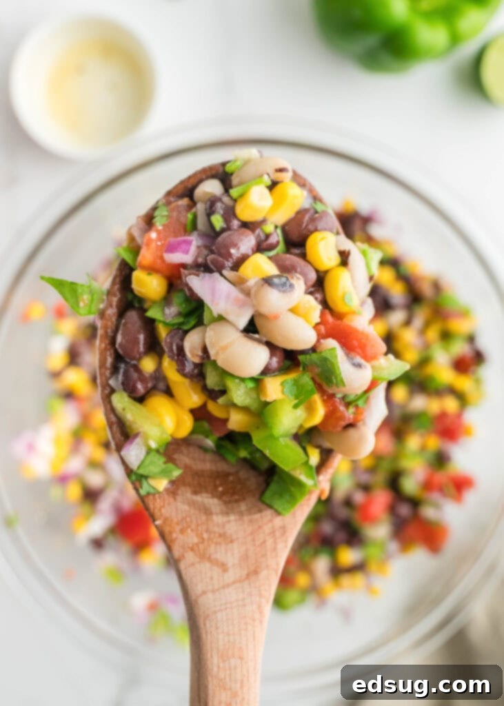 Texas Caviar 7 Scooping Texas Caviar out of a mixing bowl with a large spoon.