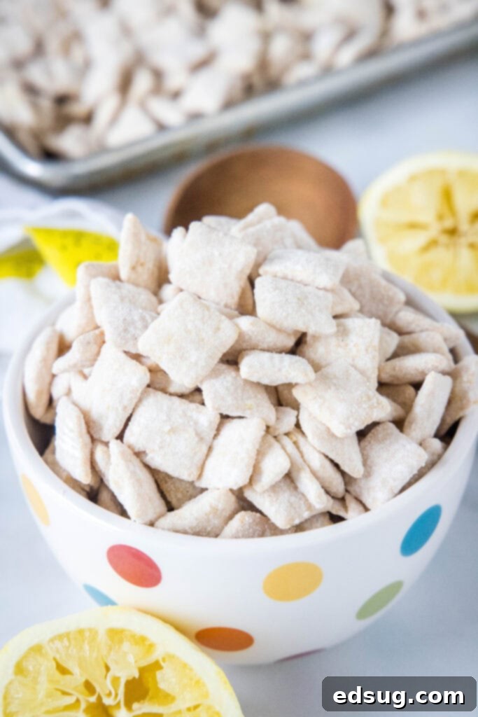 A clean, artfully arranged bowl of lemon muddy buddies, perfectly coated and ready to serve, highlighting the texture and color.