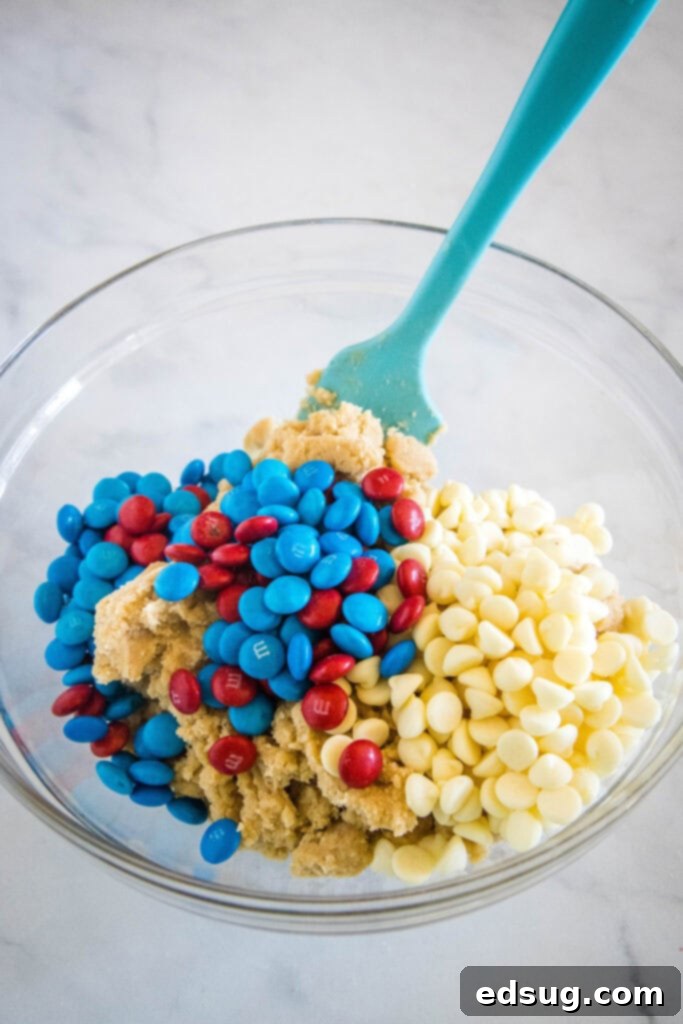 Red, White & Blue Cookies 3 Close-up shot of cookie dough being mixed with red, white, and blue M&M's and white chocolate chips.