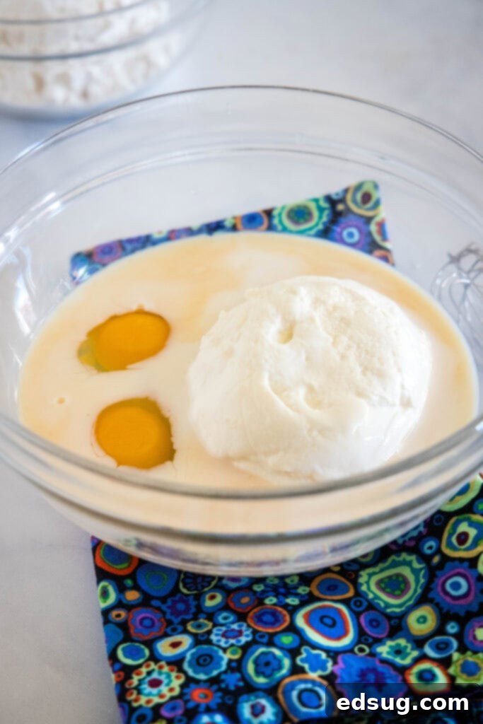 Ricotta pancakes are extra soft, fluffy, and so flavorful! Top these with syrup and a squeeze of lemon for the ultimate breakfast treat! Ricotta pancake ingredients combined in a glass bowl.