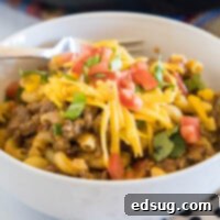A bowl of taco mac and cheese with a fork.