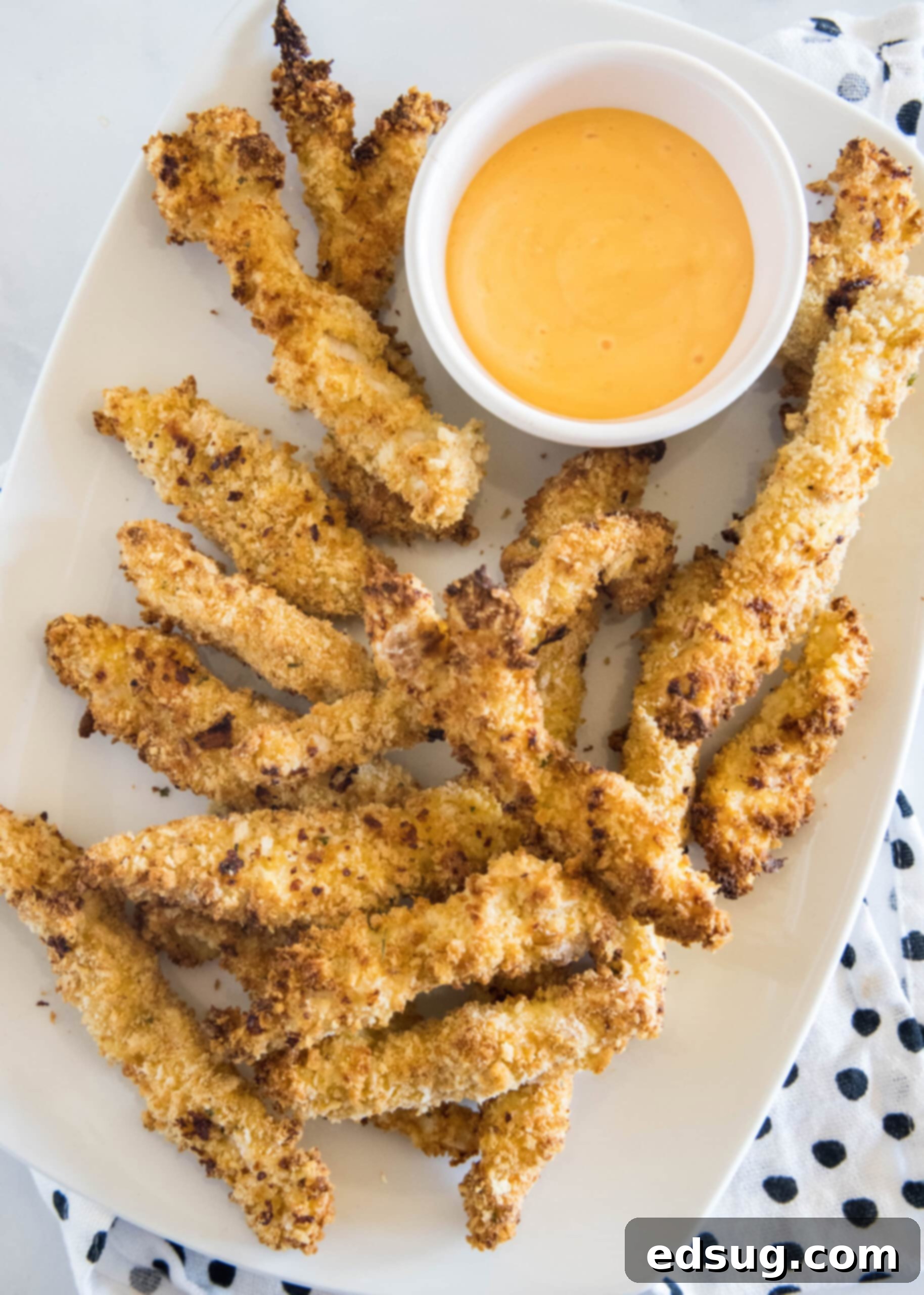 Juicy on the inside and crunchy on the outside, chicken fries are a seriously addictive appetizer or side. Ready for dipping in 20 minutes! Overhead view of chicken fries on an oval platter next to a bowl of dipping sauce.