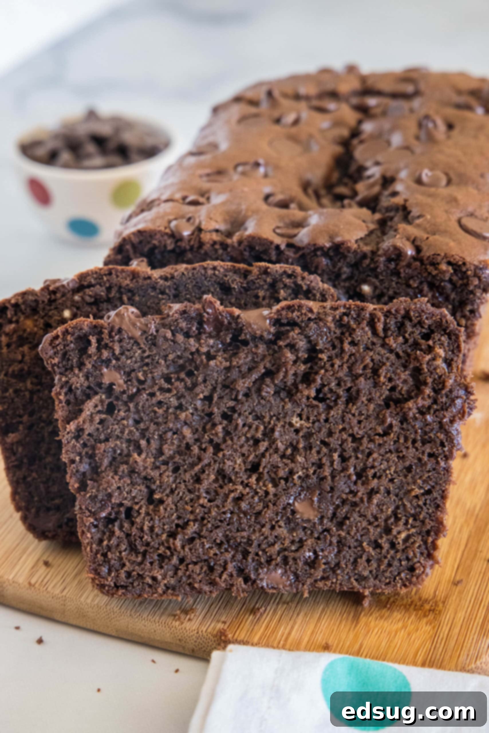 Chocolate bread with two slices cut from the end on a wooden cutting board.