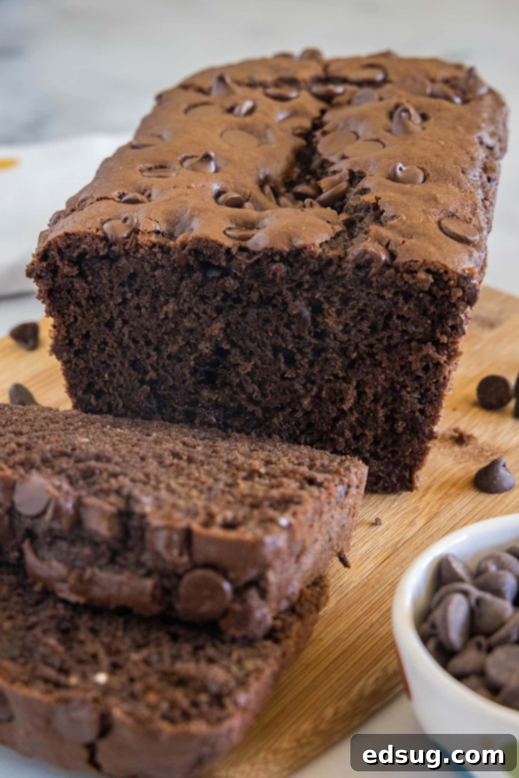 Chocolate bread with two slices cut from the end on a wooden cutting board.