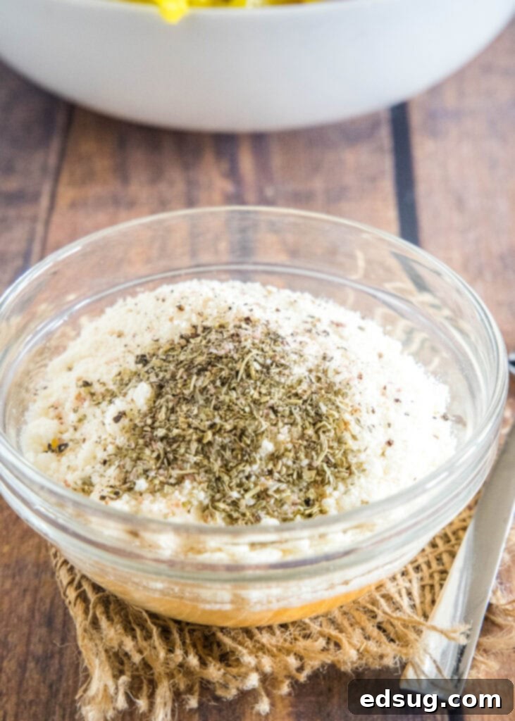 All the creamy grinder salad dressing ingredients combined in a clear glass bowl, ready to be whisked.