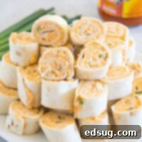 Zesty Buffalo Chicken Pinwheels 2 Buffalo chicken pinwheels stacked on a white plate.