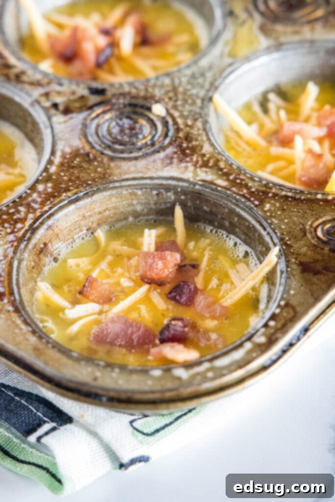 Muffin pan wells filled with unbaked bacon cheese egg muffin mixture.