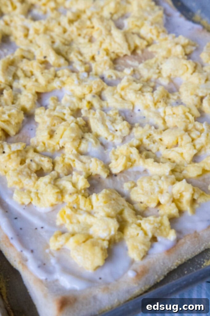 This satisfying breakfast pizza combines all of your breakfast favorites on top of a crispy pizza crust. It's so easy, baked in a sheet pan! Par-baked pizza crust topped with creamy white gravy and fluffy scrambled eggs.