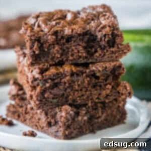 cropped close up stack of zucchini brownies on white plate