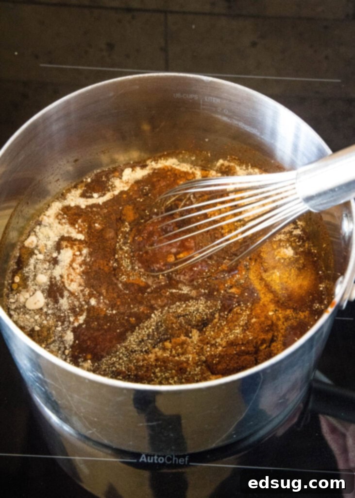 This easy homemade barbecue sauce tastes way better than store-bought! It’s sweet, tangy, and perfect on wings, ribs, grilled meat, and more. Whisking barbecue sauce ingredients together in a saucepan on the stovetop.